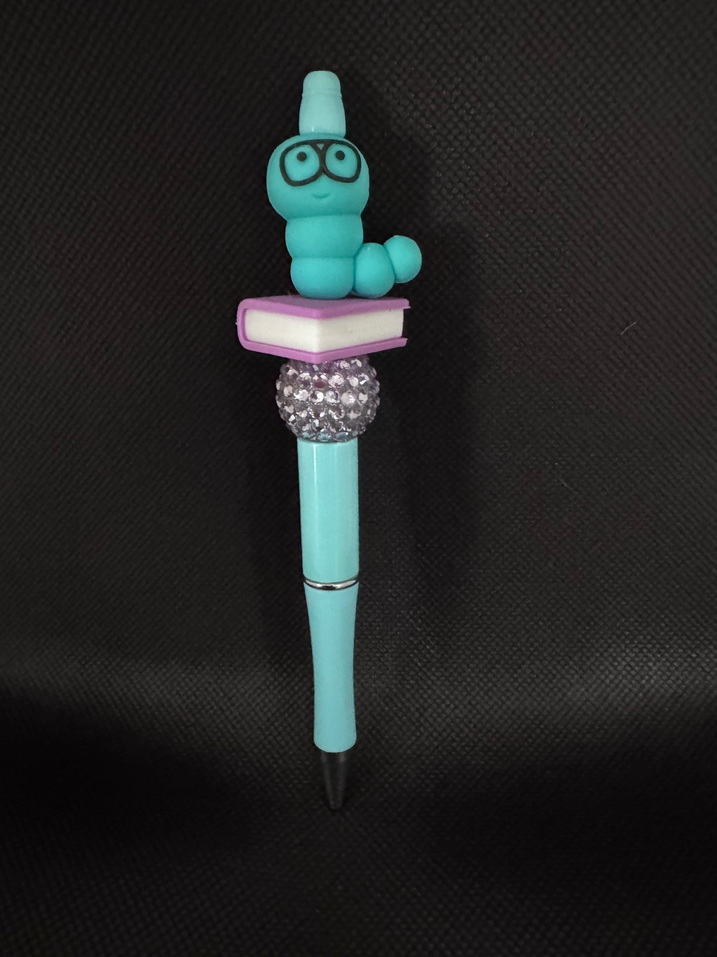 Teal bookworm with purple book