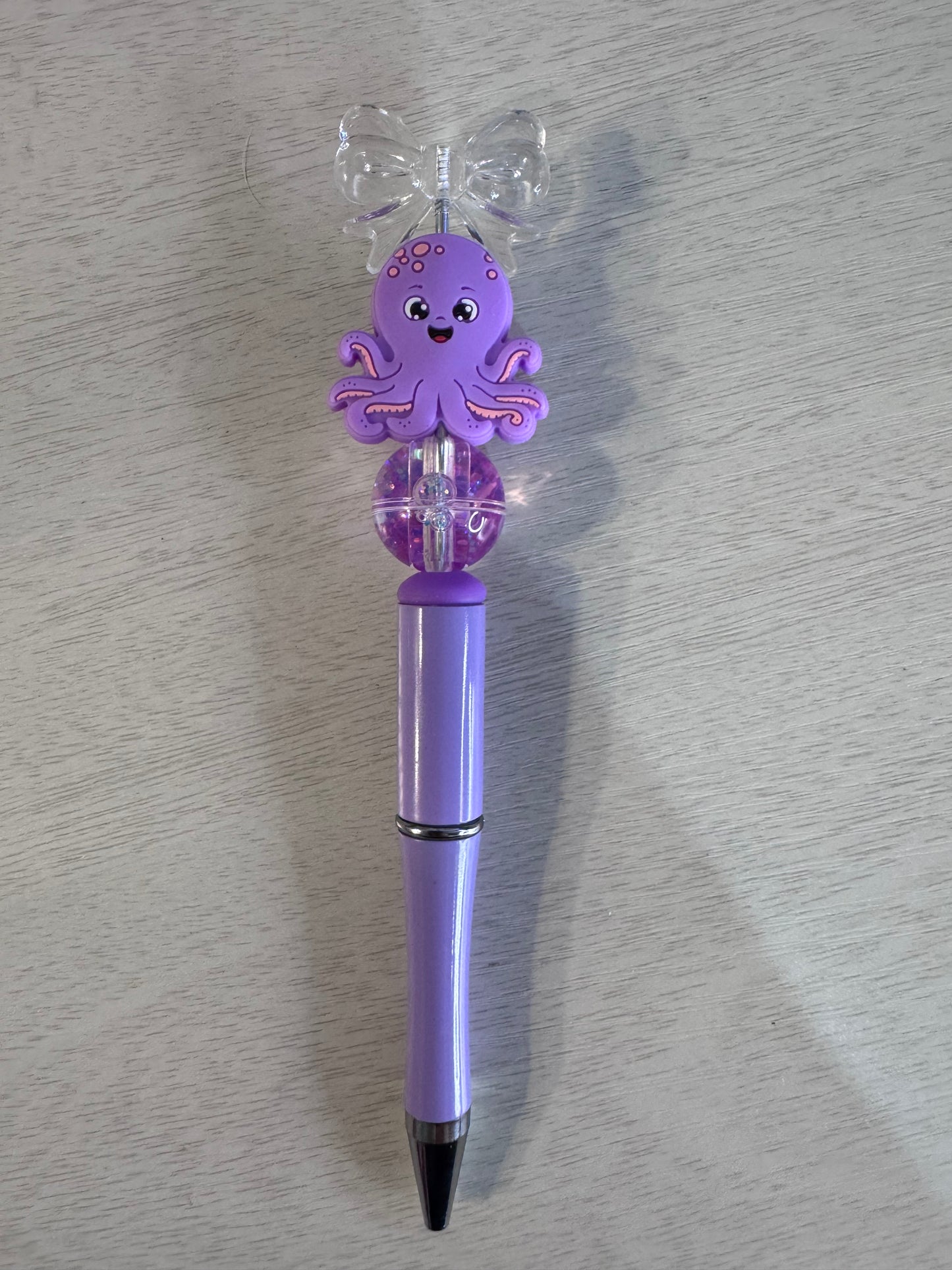 Purple octopus with bow and water bead