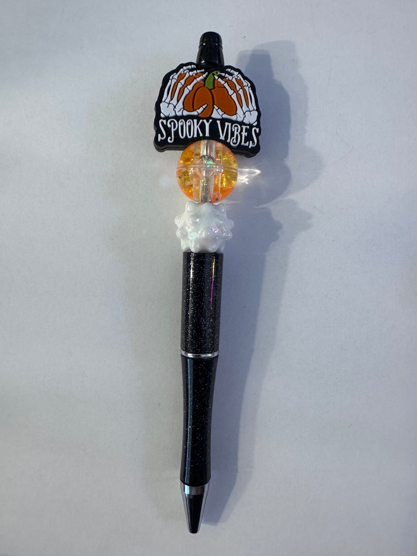 Spooky Vibes skeleton hands on pumpkin